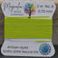 Lime green thread on a card with 'Magnolia Bead Company' branding against a wooden background