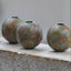 Four metallic beads on a concrete surface with a blurred background