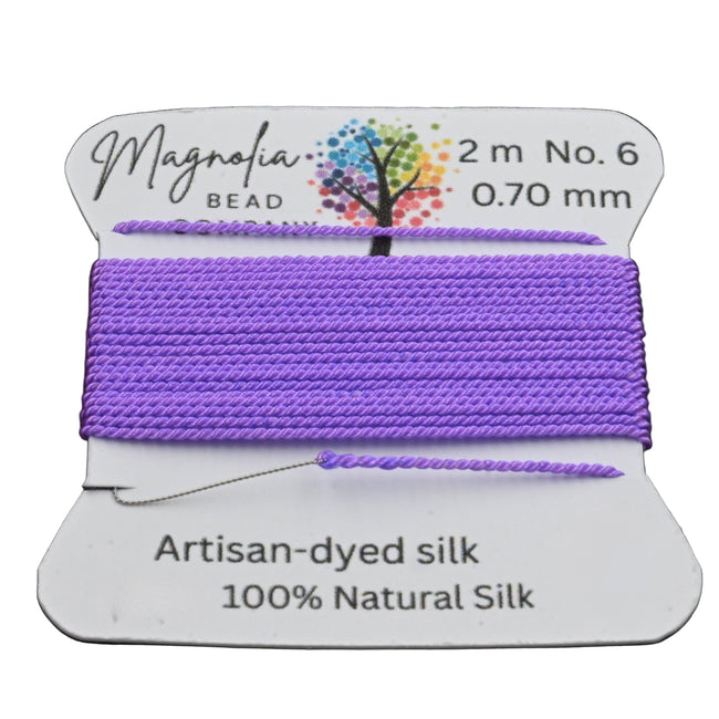 Spool of purple thread with a label on a dark textured background Hover Image