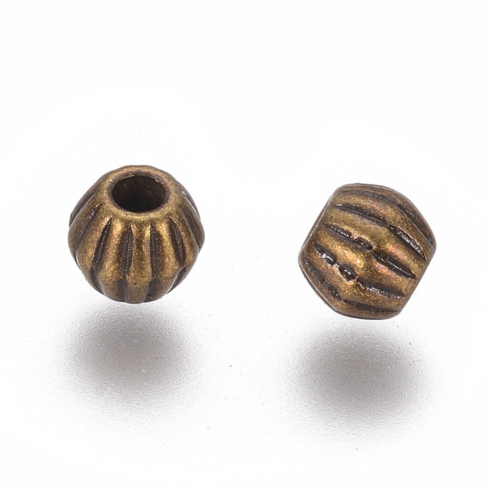 Bronze or Antique Silver, 4mm corrugated bicone. Sold per pkg of 100