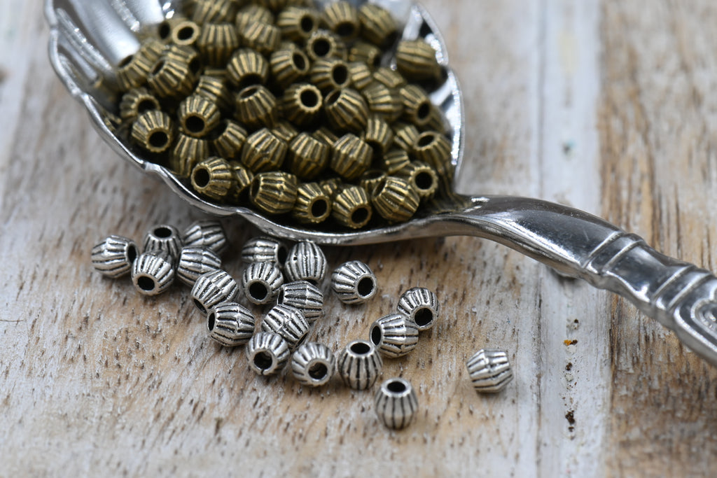 Bronze or Antique Silver, 4mm corrugated bicone. Sold per pkg of 100
