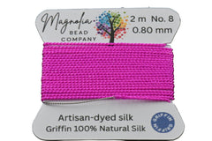 Pink thread spool with Magnolia Bead Company label on a dark background