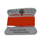 Orange thread on a Magnolia Bead Company spool with product details.