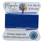 Bead thread spool with Magnolia Bead Company label on a wooden surface