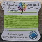 Green thread on a Griffin card with Magnolia Bead Company branding on a wooden surface.