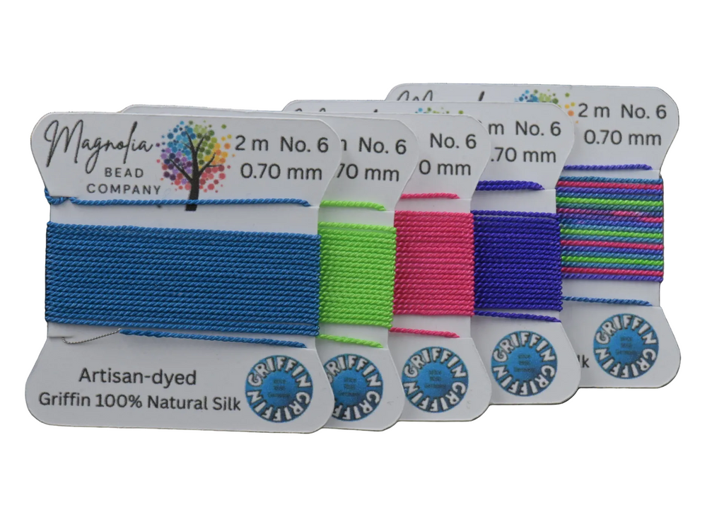Set of colorful thread spools with labels on a dark surface