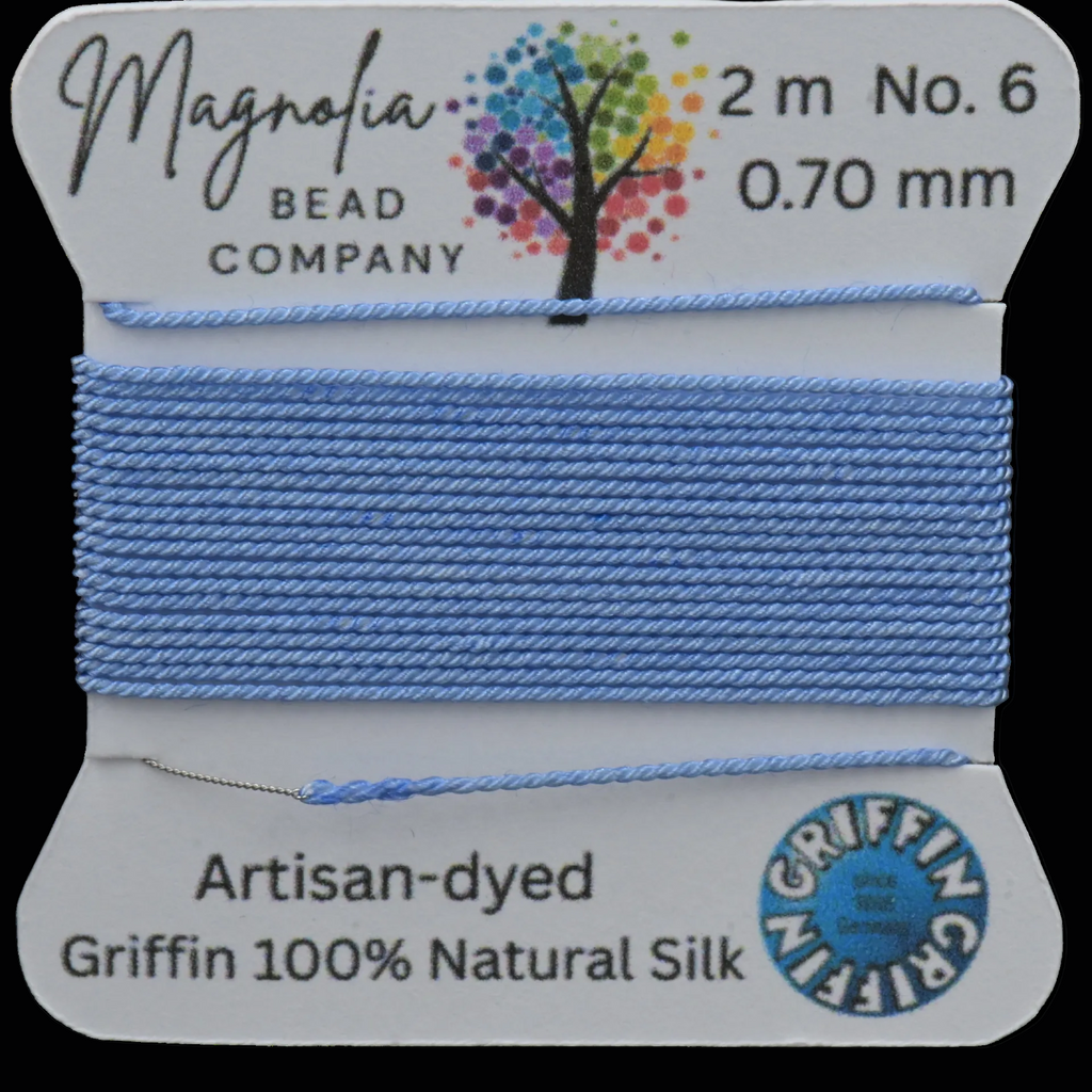 Spool of blue thread with Magnolia Bead Company branding on a white background