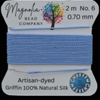 Spool of blue thread with Magnolia Bead Company branding on a white background