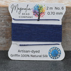 Bead thread on a card with 'Magnolia Bead Company' branding on a wooden surface.