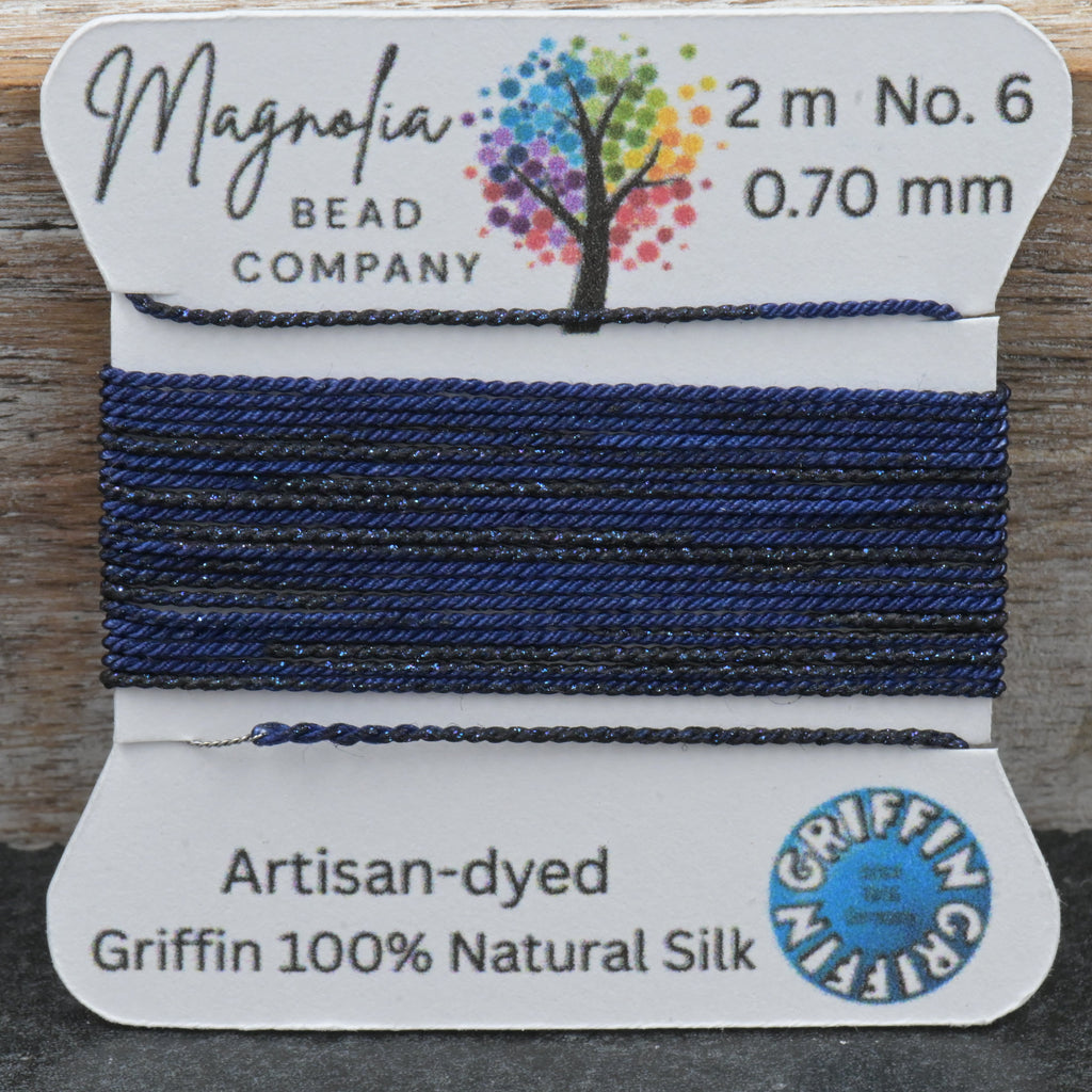Bead thread on a card with 'Magnolia Bead Company' branding, displayed against a wooden background.