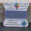 Bead thread on a card with 'Magnolia Bead Company' branding on a wooden surface.
