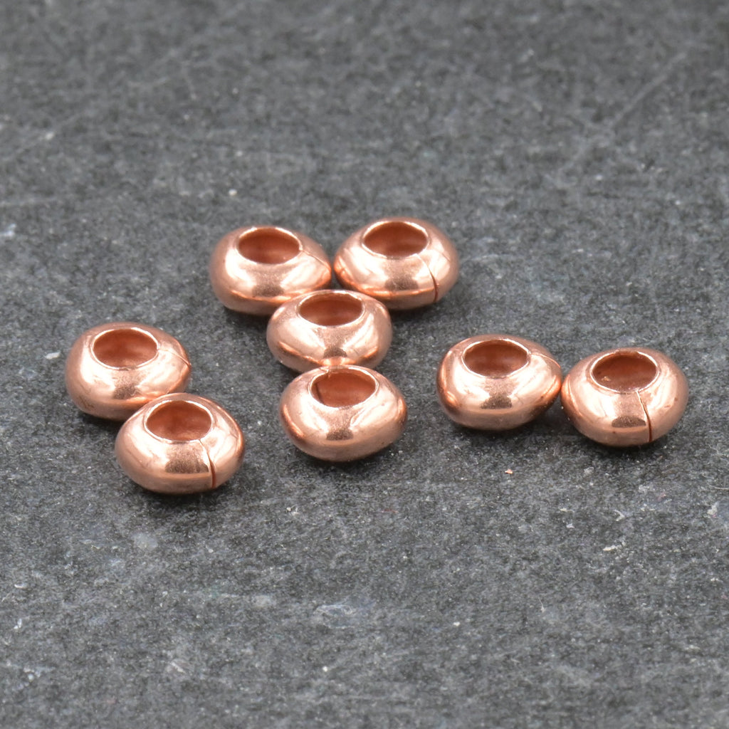 Small copper beads on a gray surface