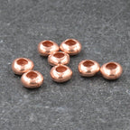 Small copper beads on a gray surface