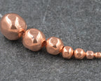 Copper beads on a gray surface