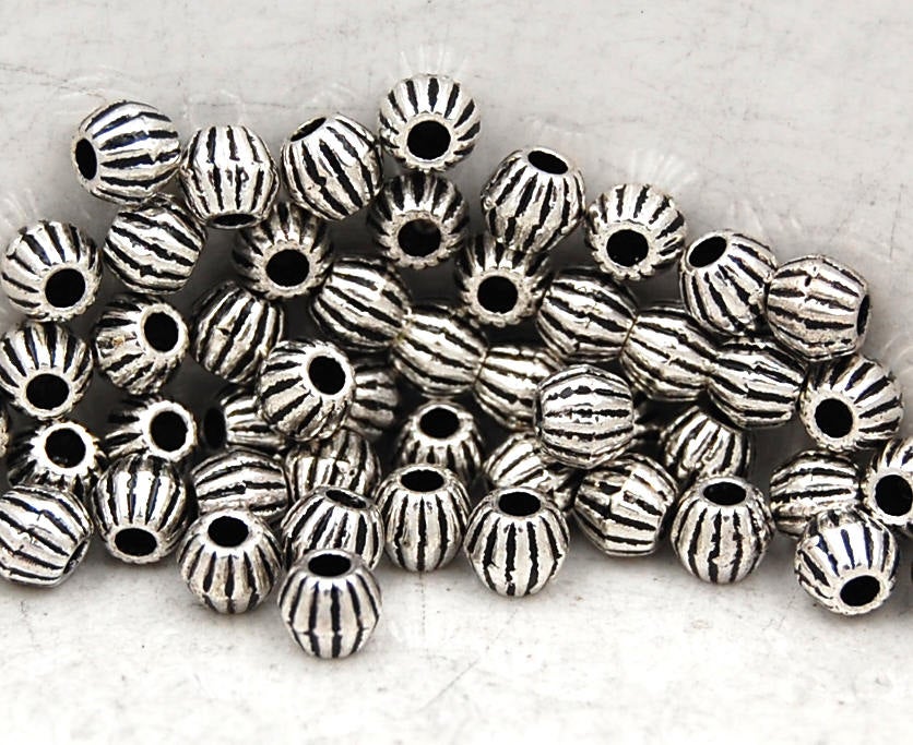 Bronze or Antique Silver, 4mm corrugated bicone. Sold per pkg of 100